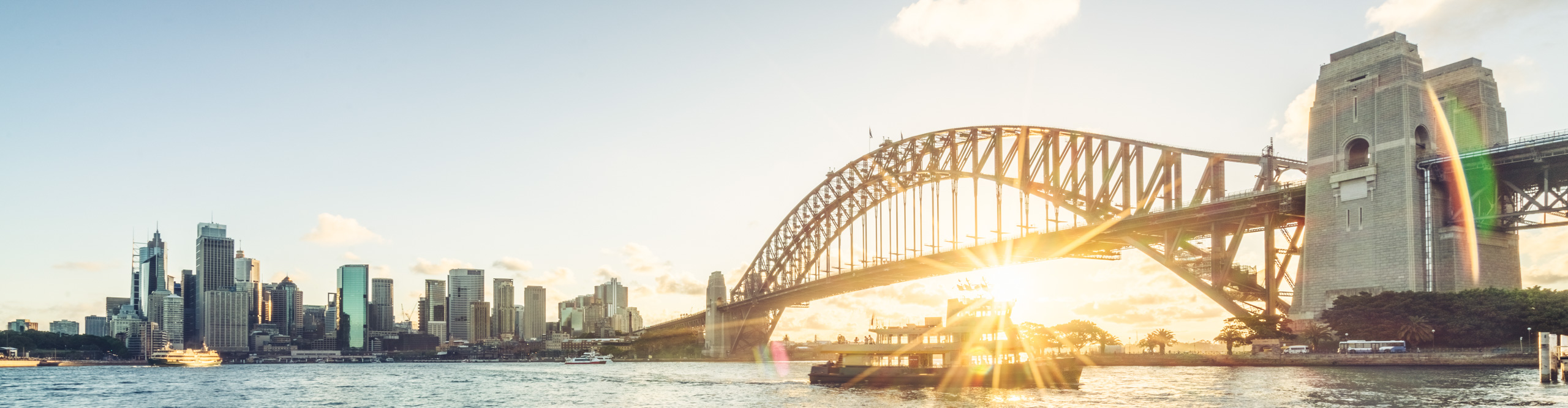 Sydney city skyline and harbour bridge against sunset sky, Australia.