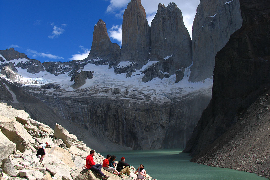 Group of travellers sitting on rocks near Cordillera Paine mountains, Torres del Paine NP