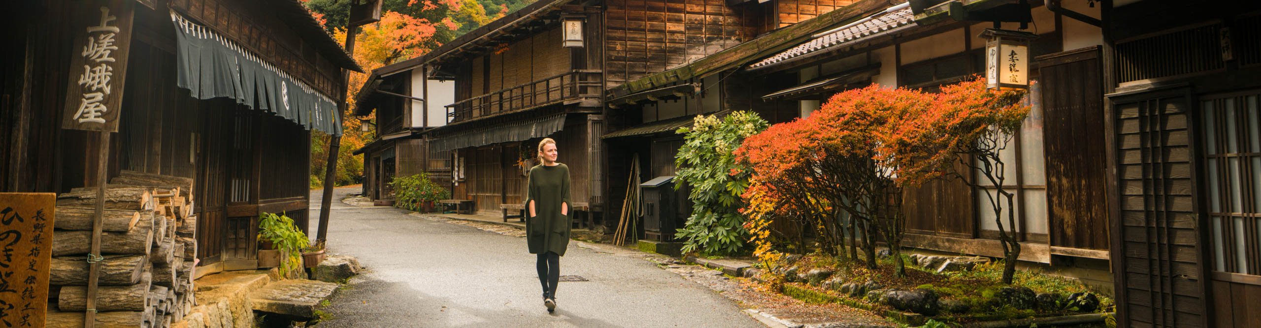 Woman walking down street line with traditional buildings  in Tsumago, Japan 