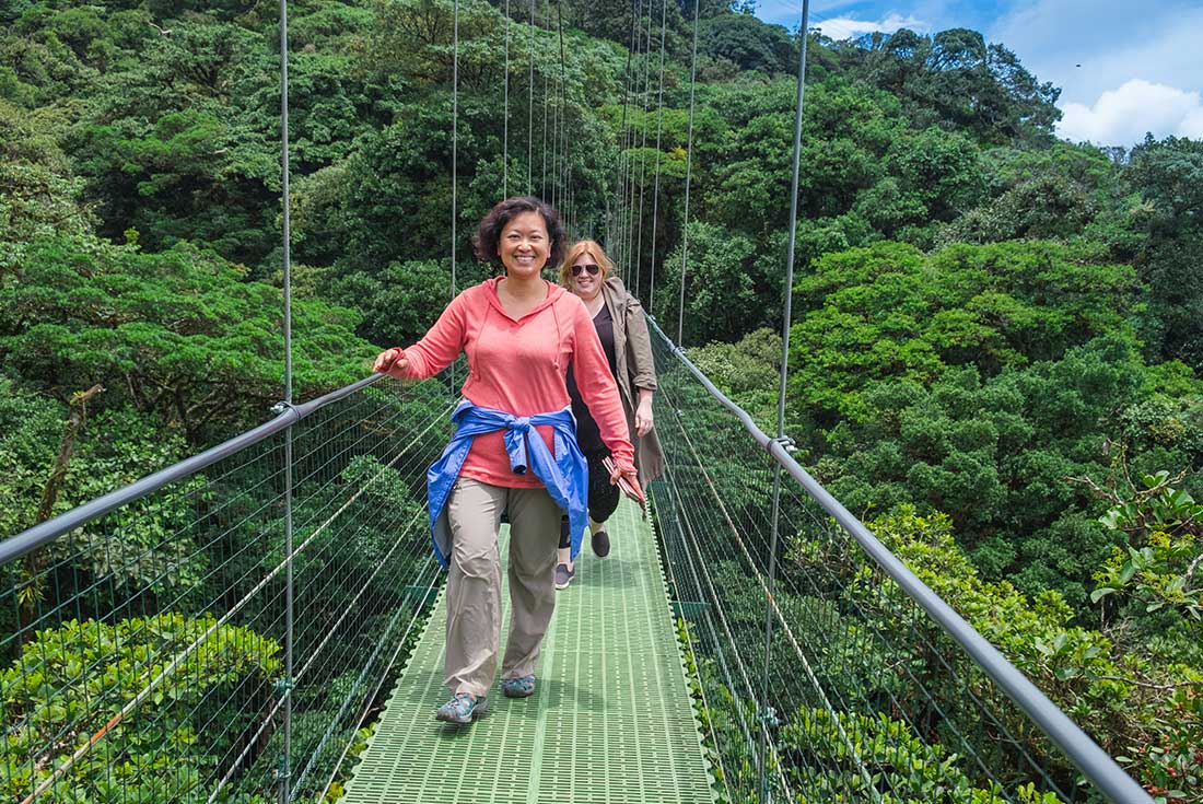 QBPR - Two travellers crossing bridge in Monteverde, Costa Rica