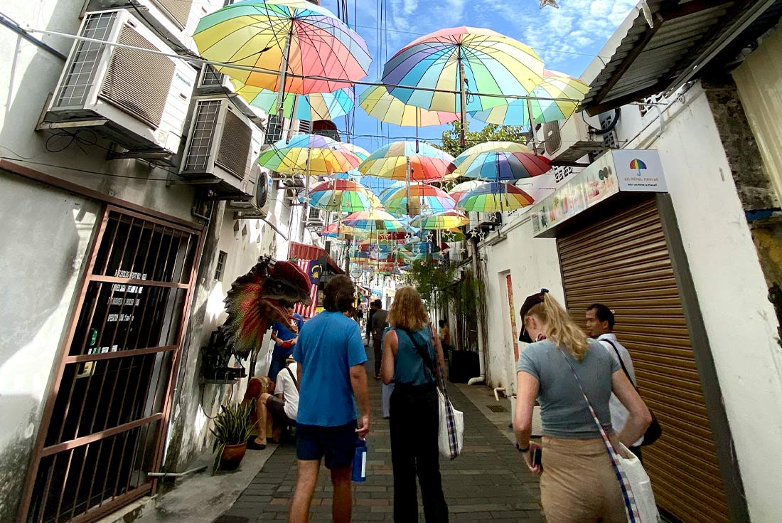Group of travellers going on orientation walk through the colourful streets of Georgetown, Penang