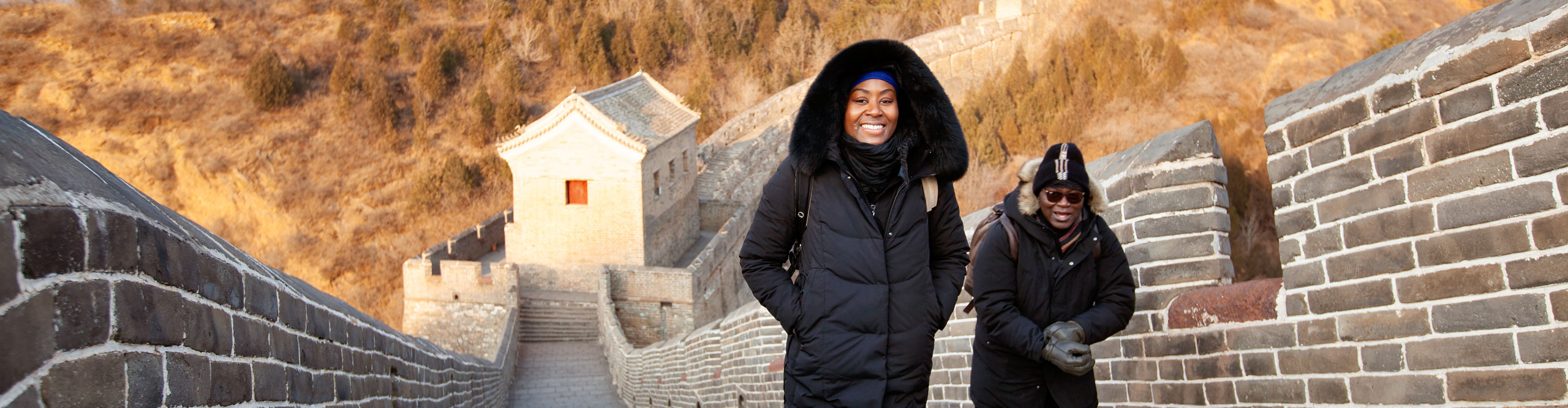Travellers walking along the Great Wall of China in the sun on a cold day