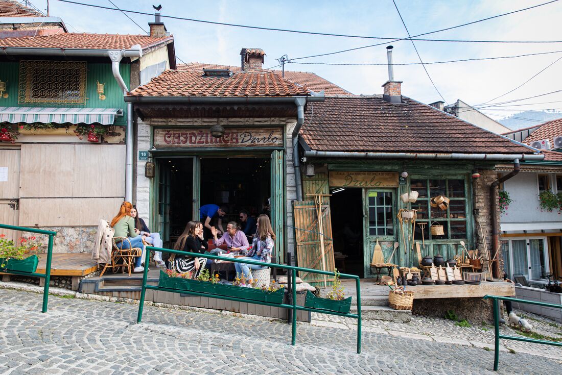 Locals sit outside a charming cafe with streetside seating in Sarajevo, Bosnia and Herzegovina