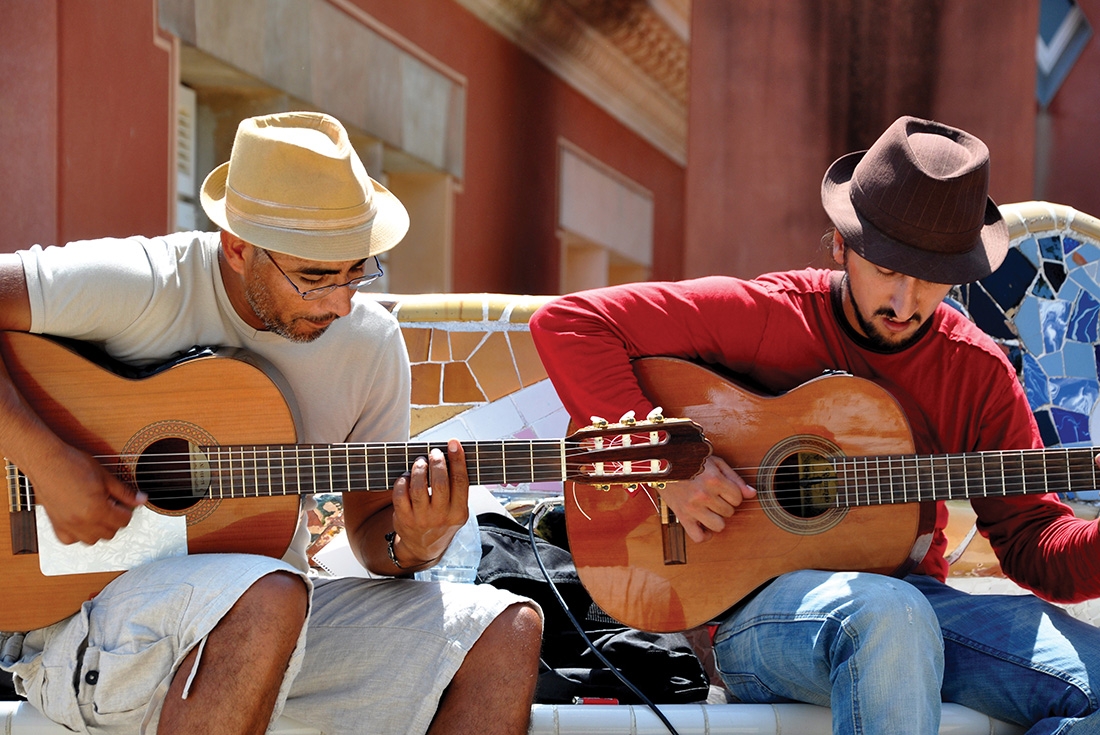Two local men playing traditional Spanish guitar in a courtyard in Barcelona, Spain