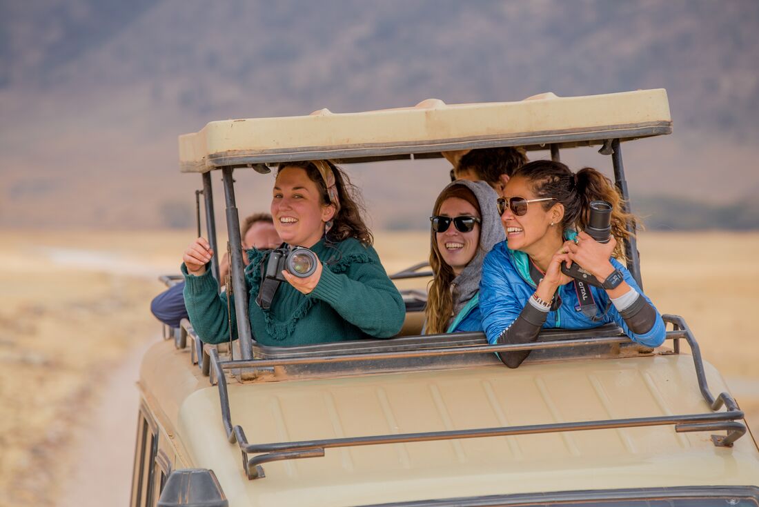Travellers take photos on Ngorongoro Safari in 4WD 