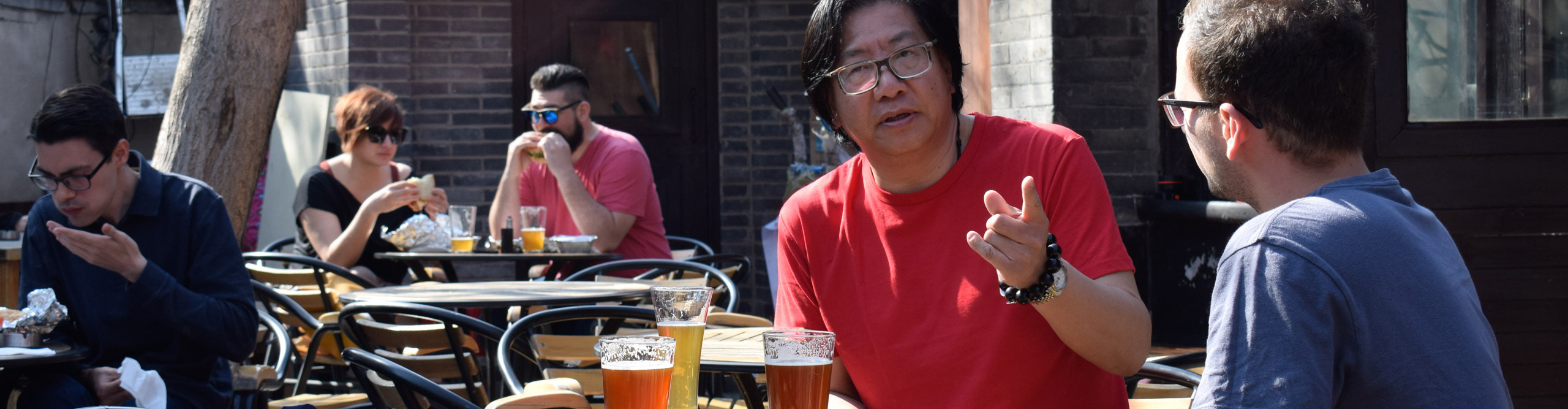 Traveller drinking beer in the sun outdoor with a guide in China 