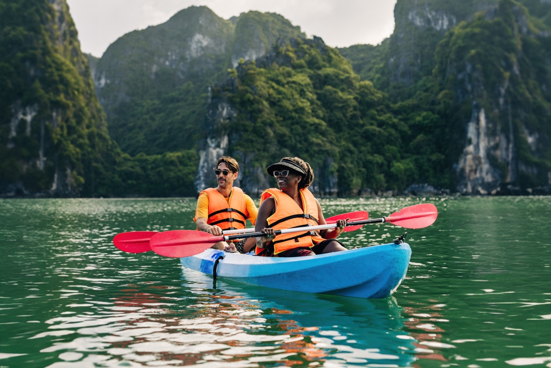Intrepid travellers pause to take in the majesty of Ha Long Bay while kayaking