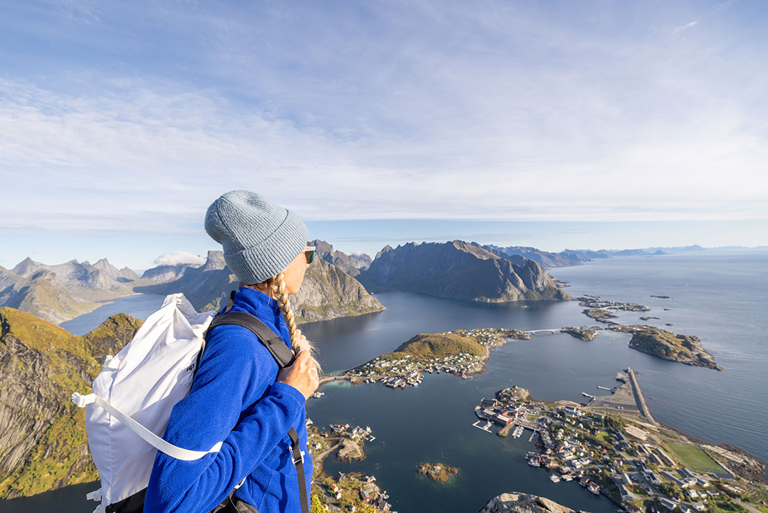 Hiker looking out at islands from view point in Lofoten, Norway
