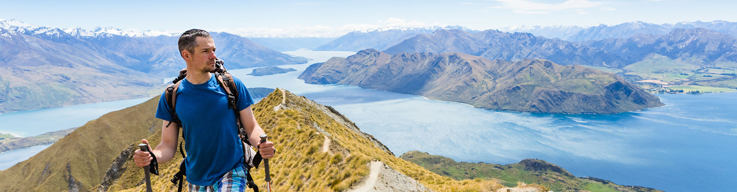 Hiker at top of the Remarkables, New Zealand, on a sunny day 