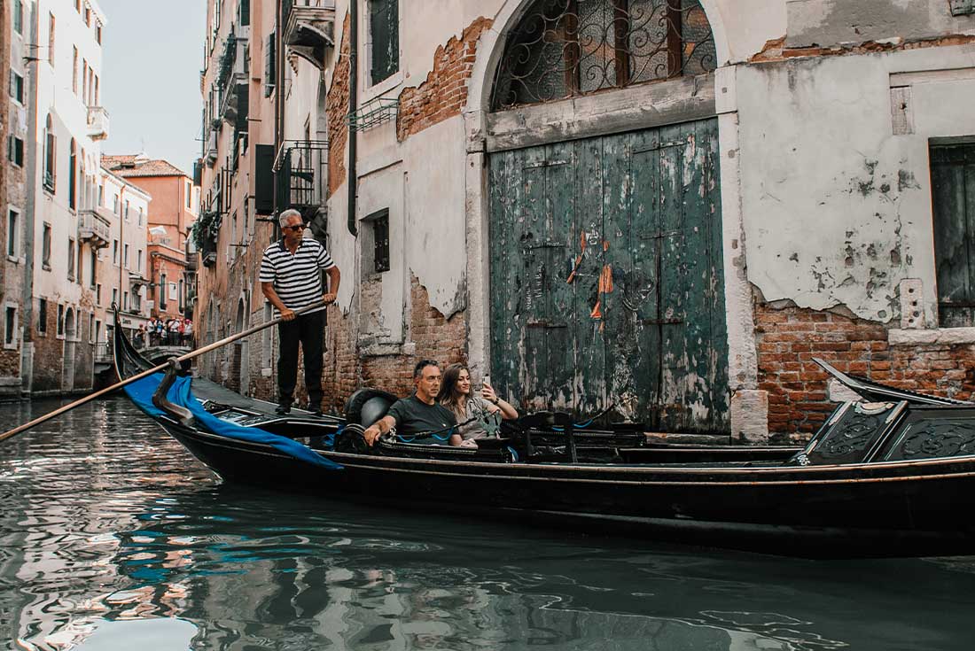 Travellers take gondola ride through canals of Venice