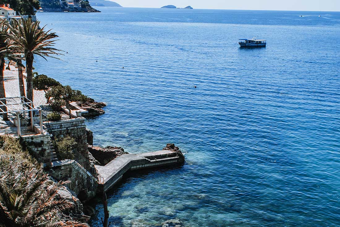 Coast of Dubrovnik with palm trees and boardwalk