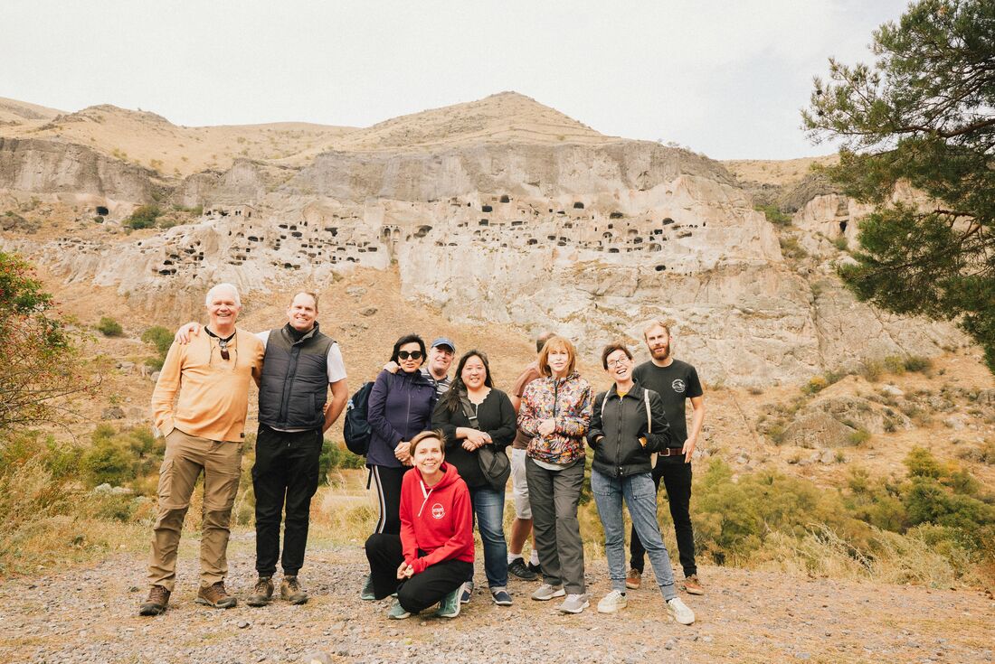 Group of Intrepid travellers and leader stand outside Vardzia cave city near Borjomi