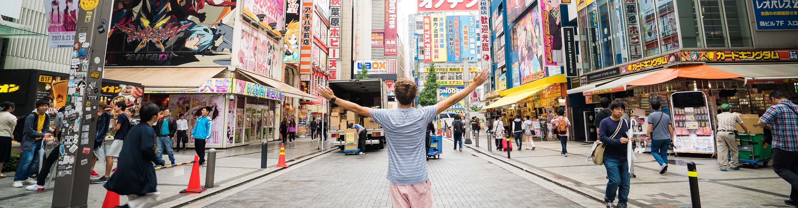 Man in Tokyo street with arms outstretched, Japan 