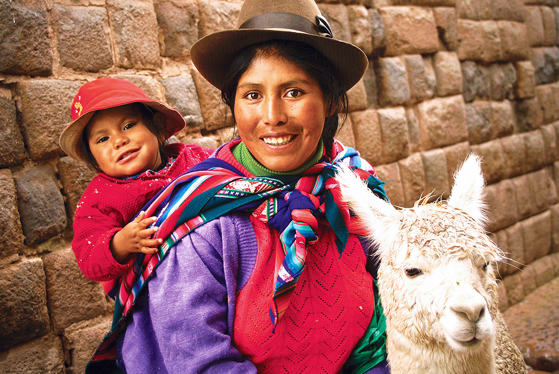 Mother and child in traditional dress with llama, Cusco, Peru