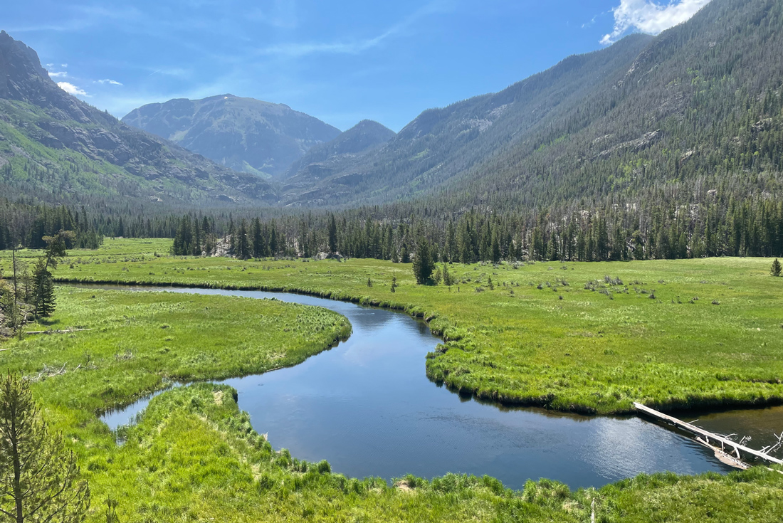 River snaking through lush valley surrounded by picturesque mountains in Colorado, USA