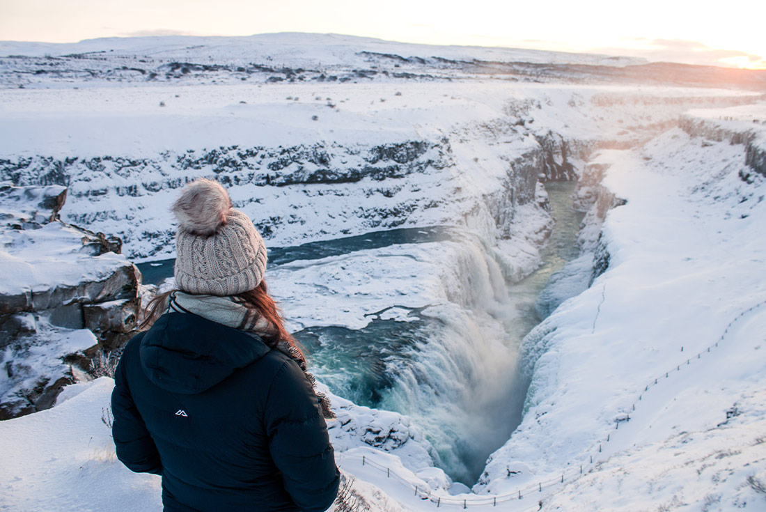 BIPI - Girl looking over Gullfoss Waterfall in winter, Iceland