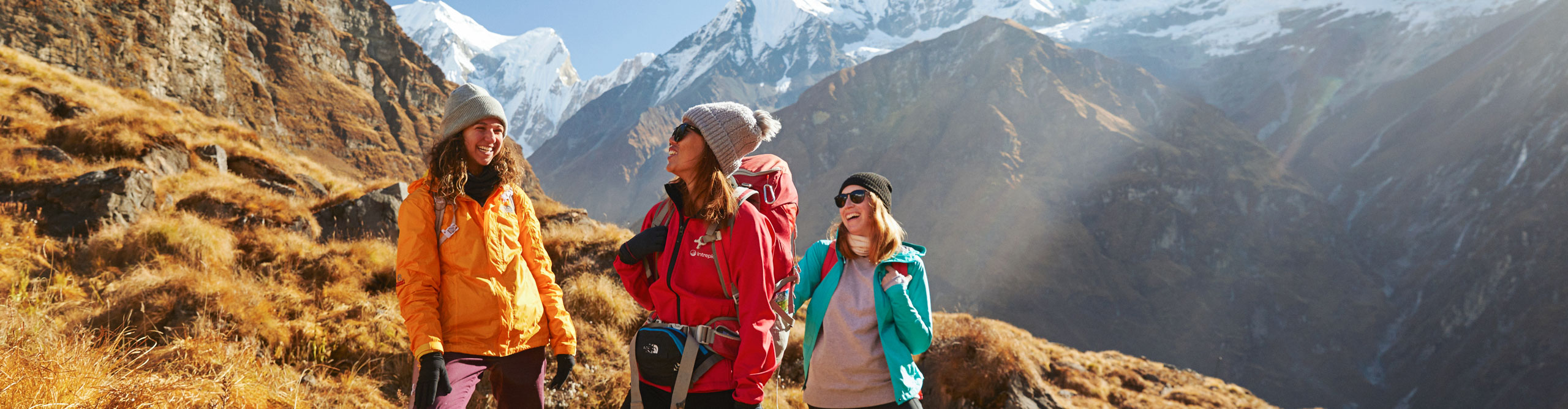 Three women surrounded by mountains at the Annapurna Basecamp