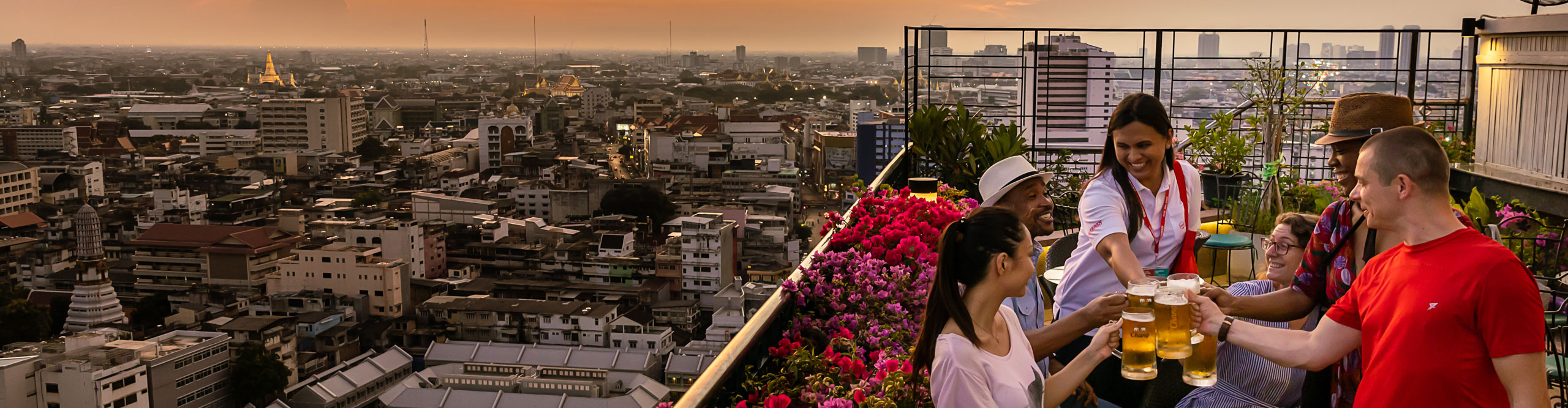 Travellers at rooftop bar. as the sun goes down in Bangkok, Thailand 