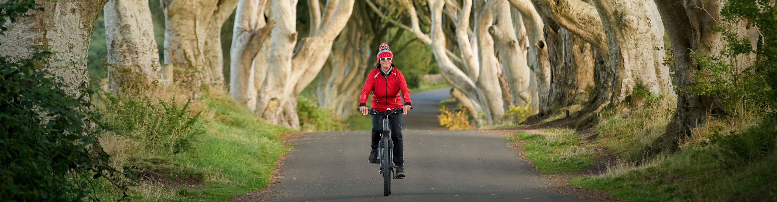 Woman cycling through the trees in southern Ireland 