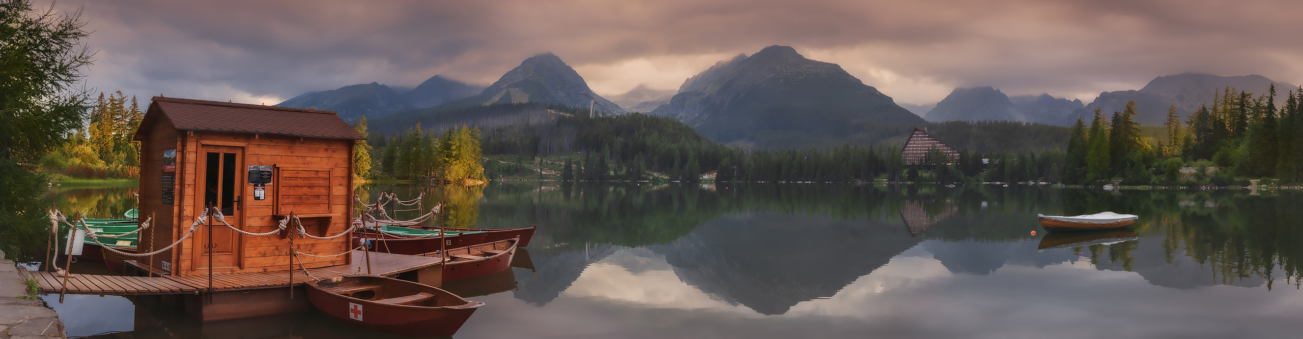 Boat hut and clouds reflected on the waters of the Strbske Pleso in the Tatras Mountains, Slovakia 