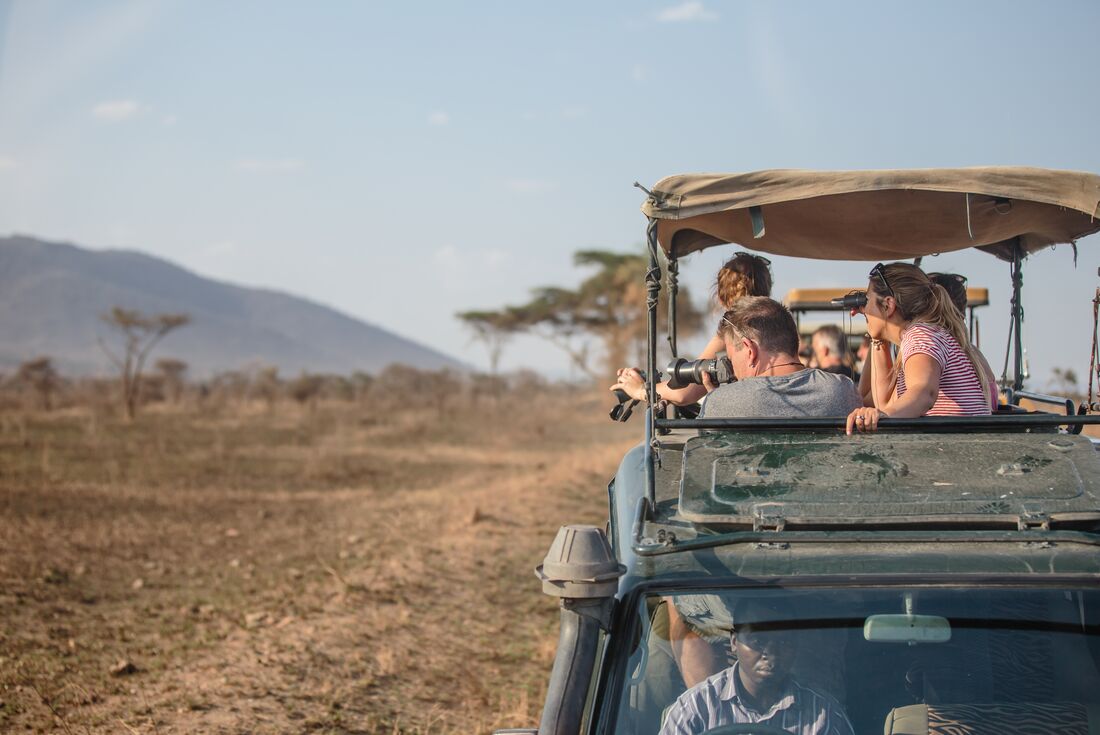Travellers on board Safari vehicle in the Serengeti 