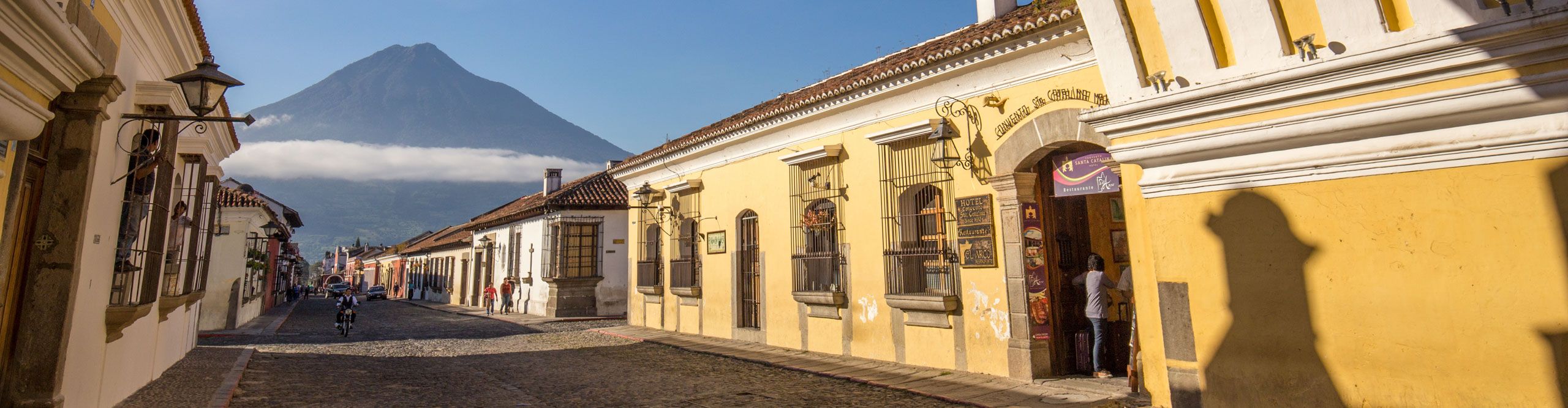 Street in Antigua with mountains in the distance in the late afternoon sun, Guatemala 