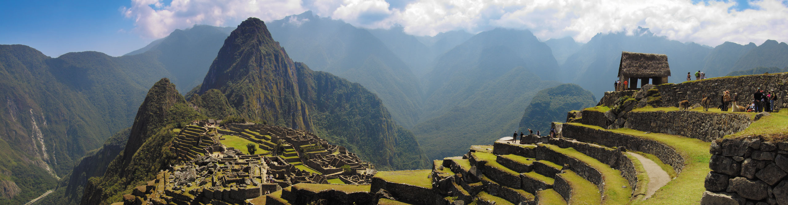 Clouds rising above the mountains behind. the ruins of Machu Picchu, in Peru