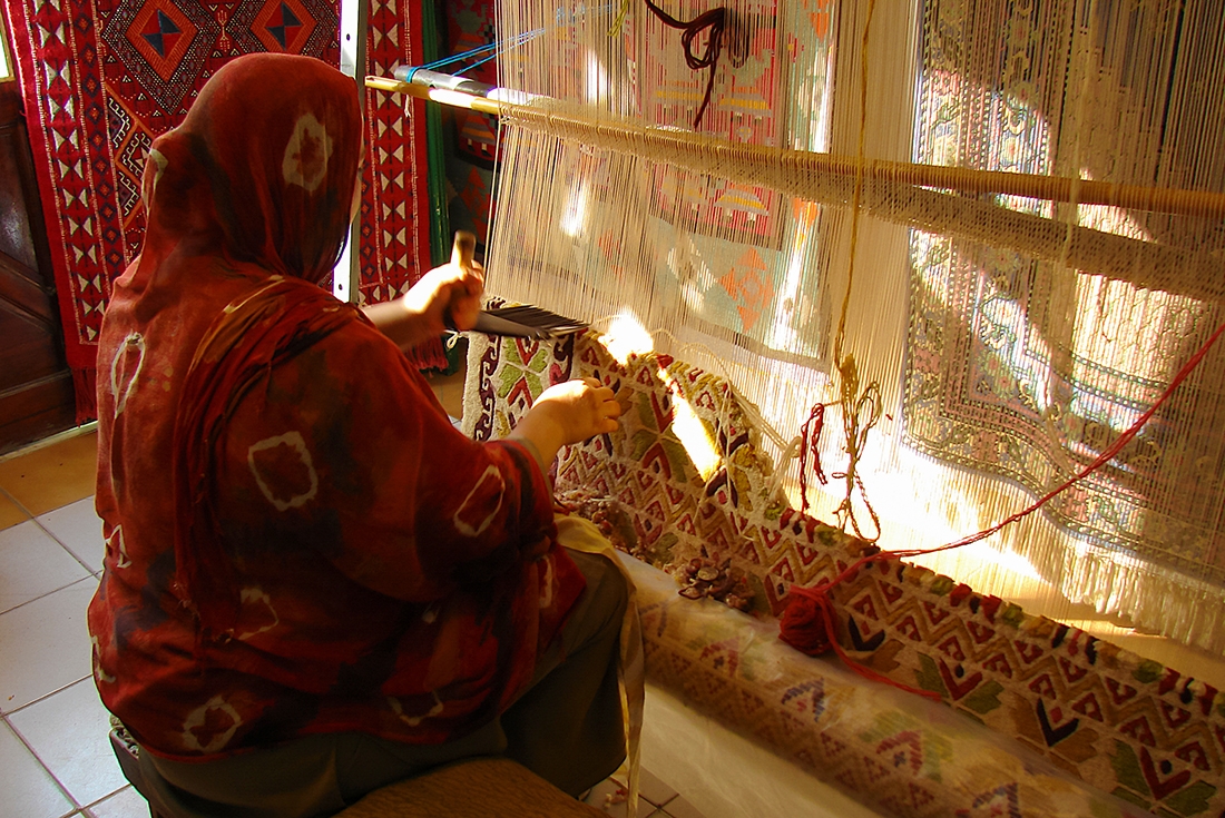 Local woman makes a colourful traditional woolen carpet by hand, Tunisia