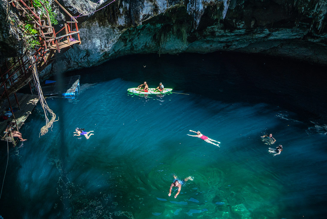 Travellers swimming in hate Cenotes, Mexico