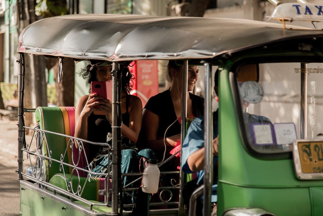 Passengers take photo on Tuk Tuk in Bangkok