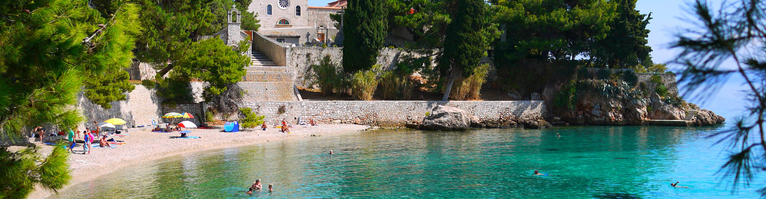 People swimming in bay with clear blue water, Croatia