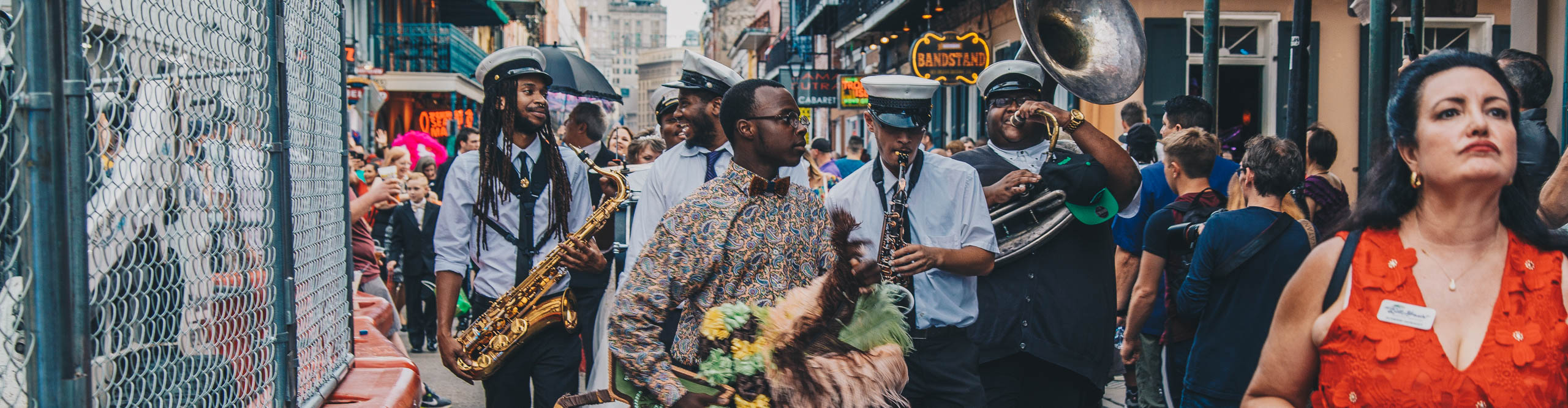 Brass band walking down the street, woman dancing, during Mardi Gras in New Orleans, Louisiana, USA