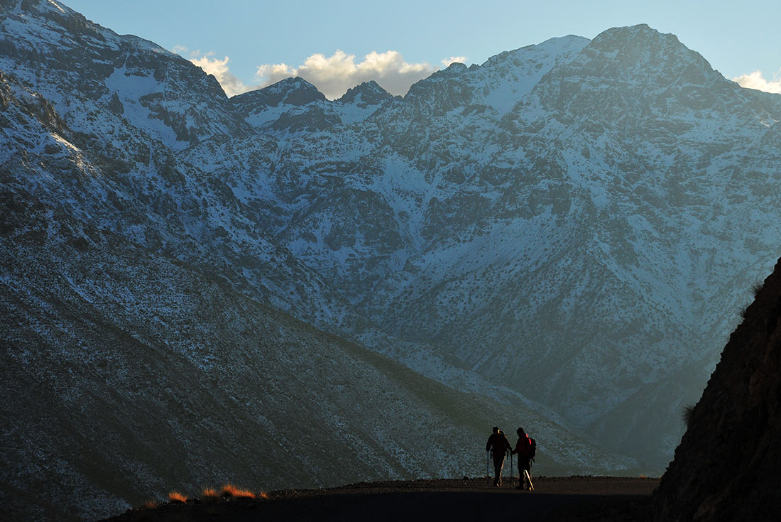 Travellers hiking the High Atlas Mountains during sunrise in Morocco 