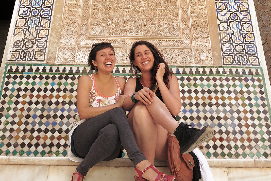 Intrepid Travellers sitting on steps in front of mosaic wall, Granada, Spain
