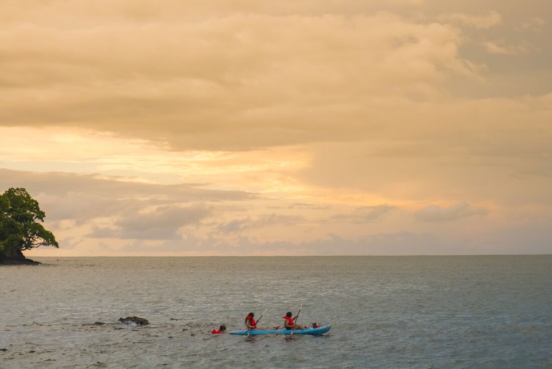 Travellers snorkelling and kayaking at sunset, Manuel Antonio, Costa Rica