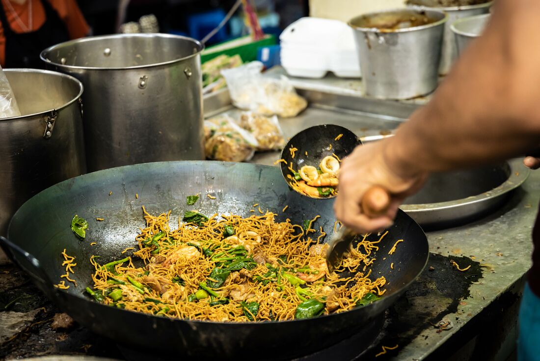 Streetfood vendor in Bangkok frys noodles