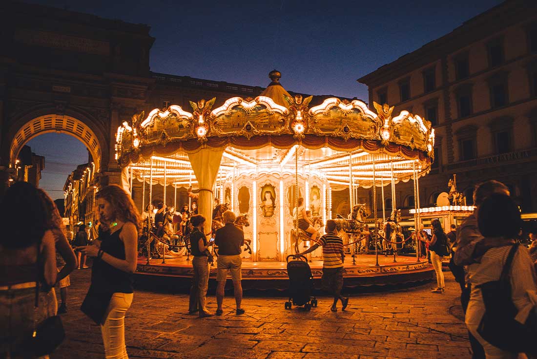 Carnival lights and merry go round at night time in Florence