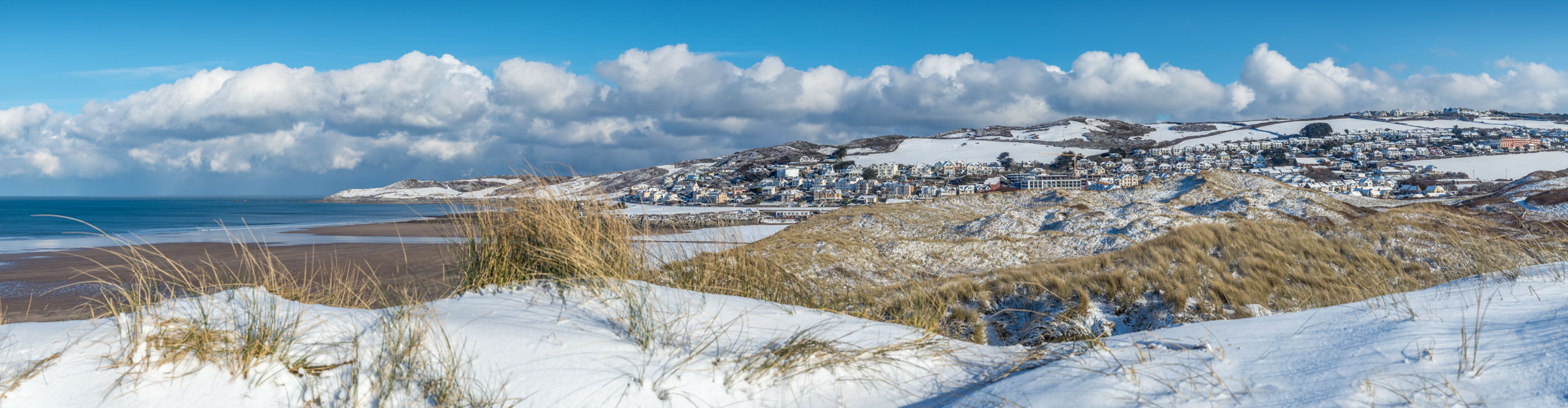 Snow on Woolcombe beach, on a sunny day in Devon, England 
