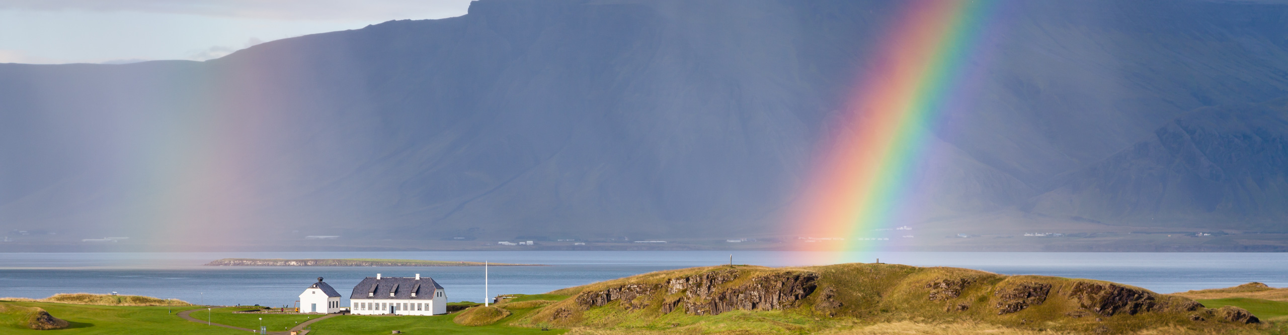 Rainbow over the harbour with mountains in the background, near Reykjavik, Iceland