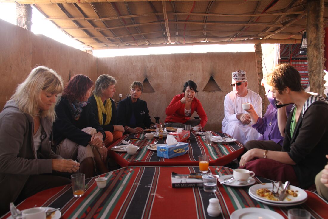Intrepid travellers enjoy lunch with Bedouin peoples in Wahiba Sands, Oman