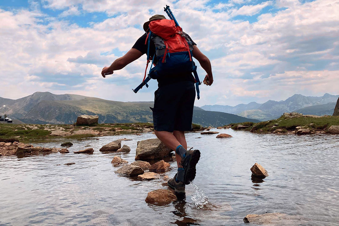 Hiker crossing a river, Andorra