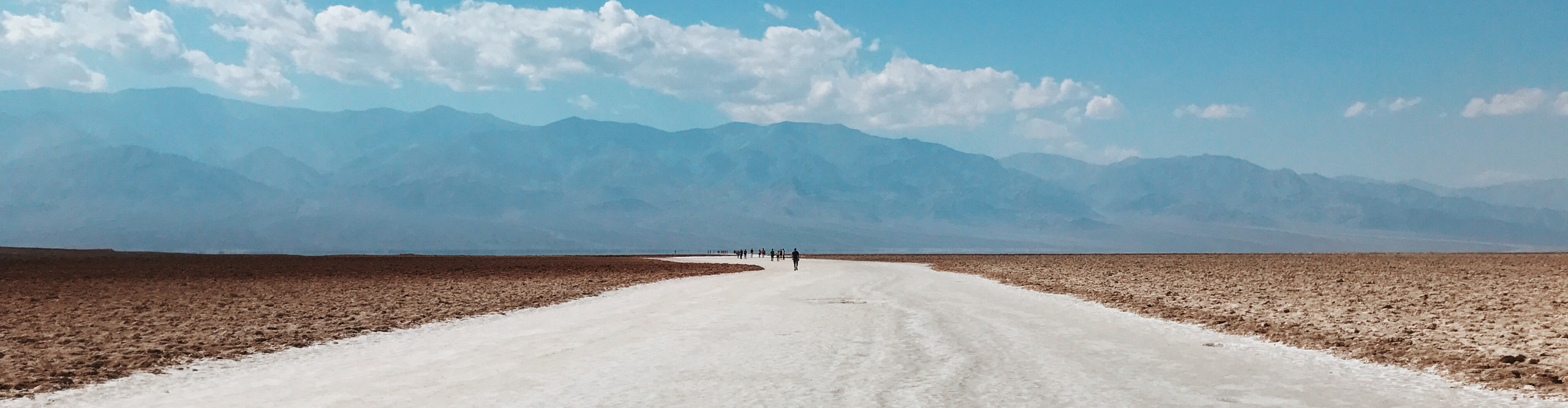 Travellers walking on Road through Death Valley on a clear sunny day California, USA