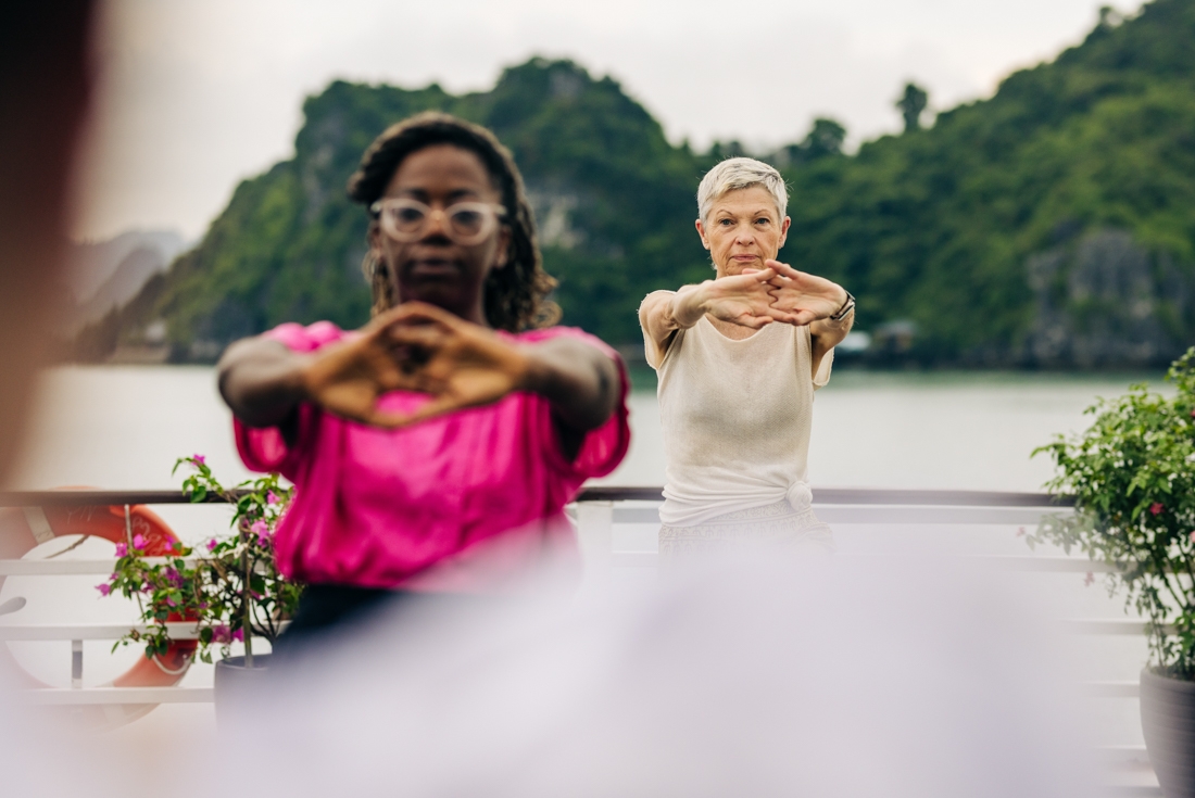 Intrepid travellers do some tai chi on a boat in Ha Long Bay