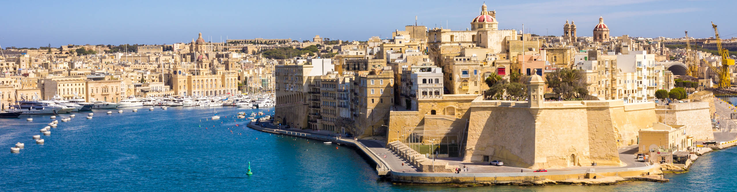 View of Paola City from Valletta Waterfront with boats in the harbour on a sunny day in Malta 