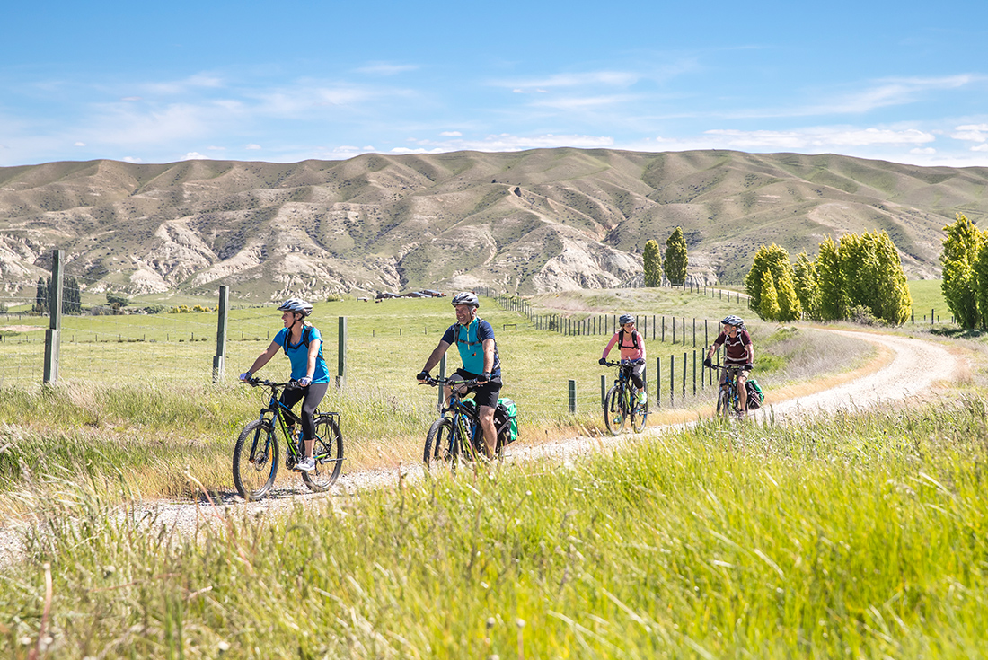 Cycling in beautiful fields on the Otago Central Rail Trail, New Zealand