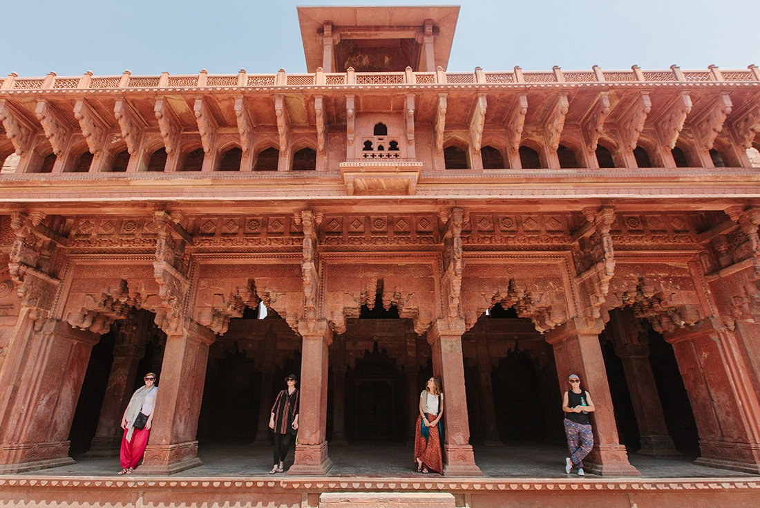 Travellers standing in the elaborate doorways of Red Fort in Agra, India on an Intrepid Travel tour.