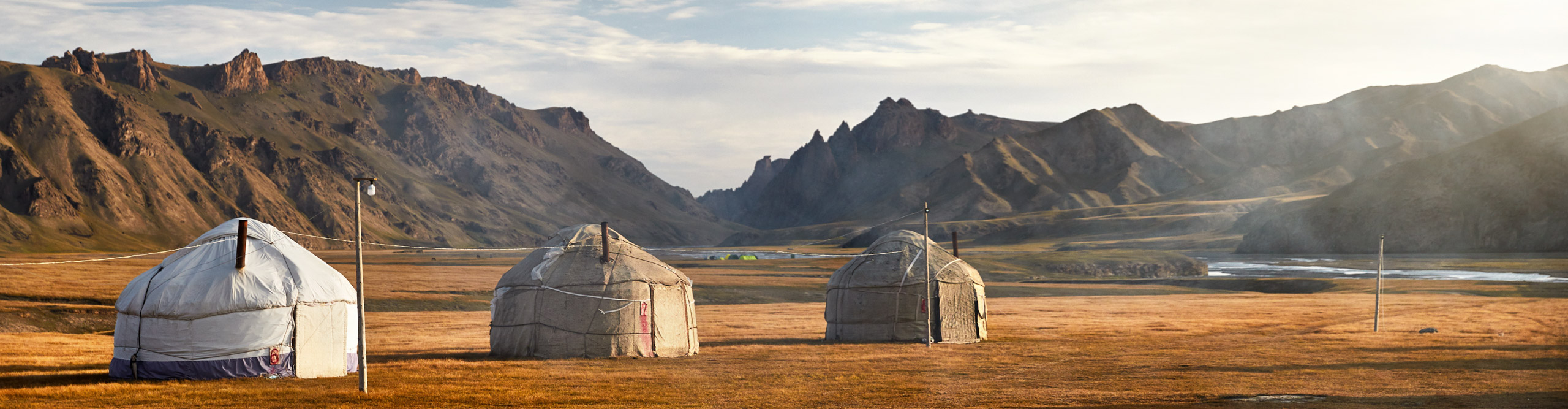 Round Yurt nomadic houses camp at mountain valley in Kyrgyzstan, at dusk 