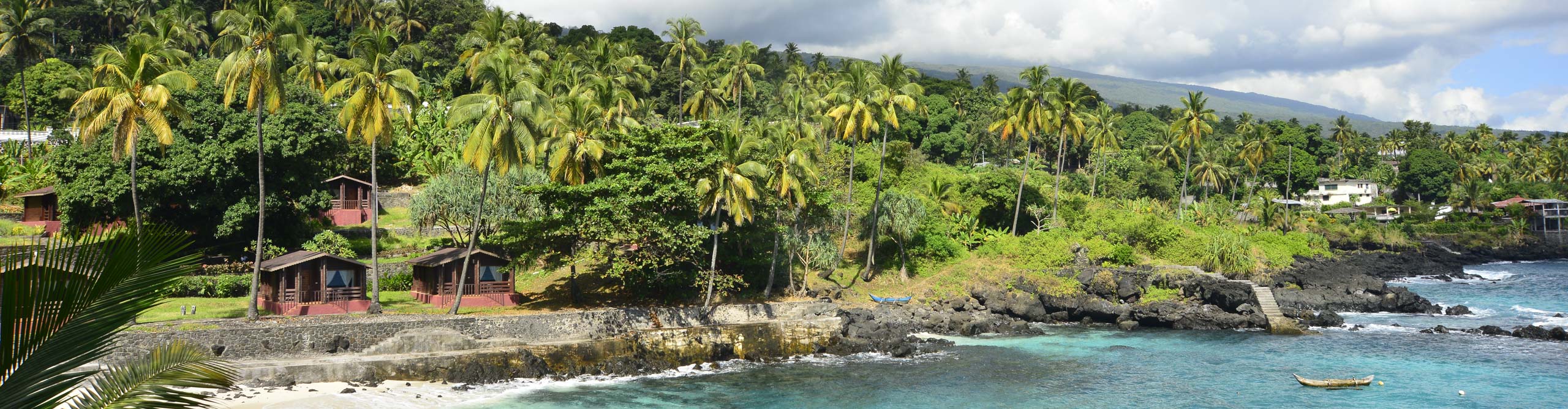 Natural Bay of Comoros Island with houses surrounded by palm tree and crystal clear water, Africa 