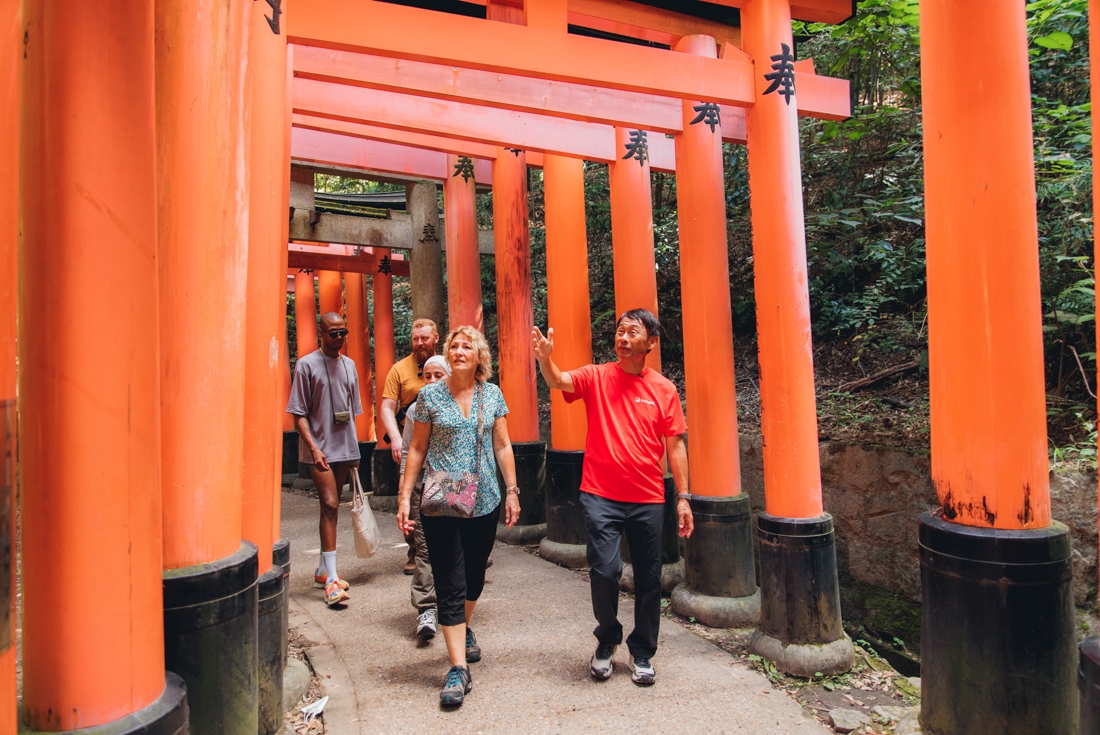 Intrepid leader shares information as travellers walk through the Fushimi Inari gates