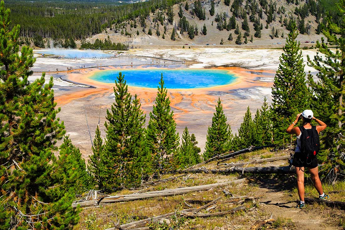A hiker at Yellowstone National Park's Grand Prismatic Spring, Montana, USA